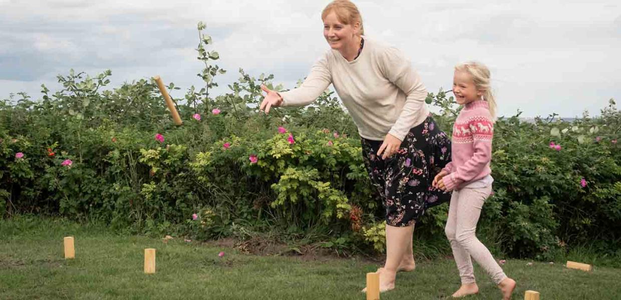 Mor og datter spiller konngespil i haven ved sommerhuset